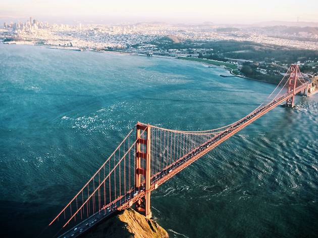 Aerial view of the Golden Gate Bridge in San Francisco with the city skyline and ocean in the background, illustrating a large-scale land survey or mapping project.