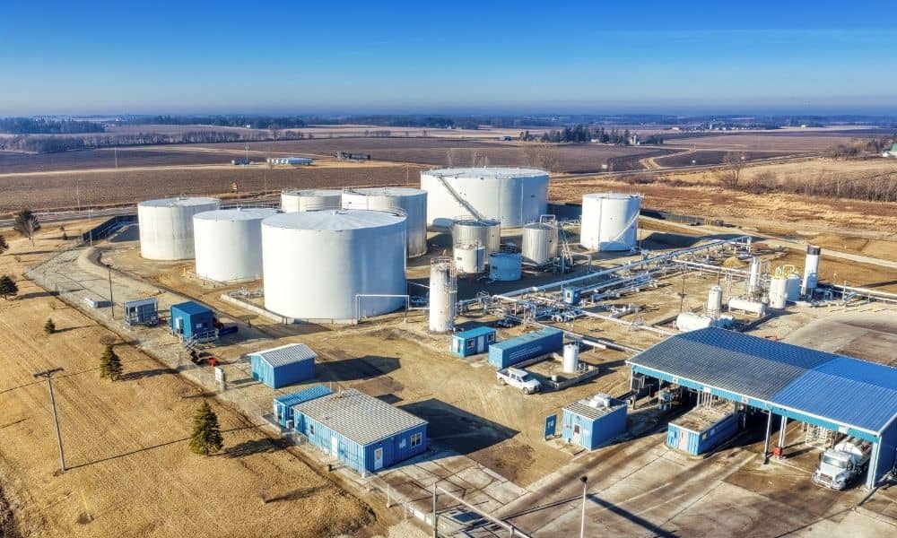 Alta survey expanding manufacturing facility | ALTA Land Survey Aerial view of an industrial facility with storage tanks, buildings, piping, and surrounding land, with an ALTA survey providing site context